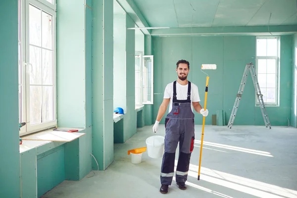 Pintor barbudo trabajador de la construcción en una obra de construcción . — Foto de Stock