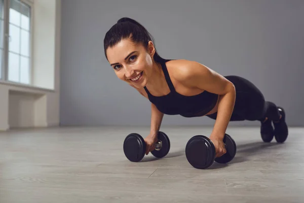 Ejercicio de flexiones. Chica atlética en ropa deportiva negro haciendo ejercicios push-up en interiores . — Foto de Stock