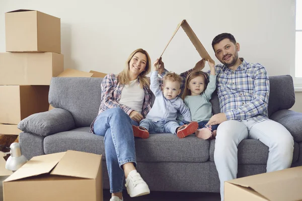 Familia feliz sonriendo en una casa nueva moviéndose . — Foto de Stock