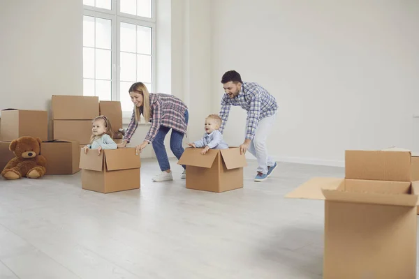 Familia feliz divertirse jugando en una nueva casa en la habitación. — Foto de Stock