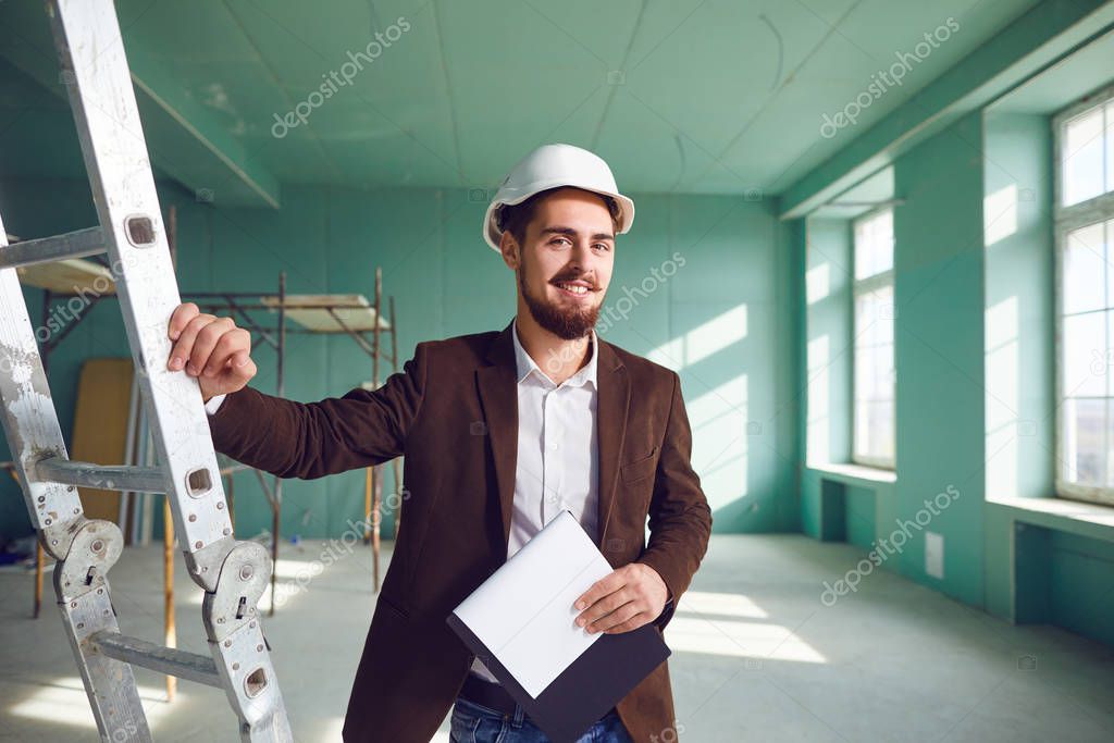 Contractor bearded man in a white helmet in a room at a construction site