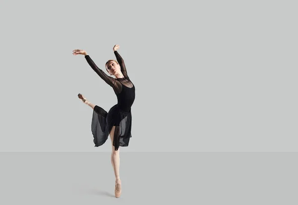 Kobieta baletnica na szarym tle. — Zdjęcie stockowe