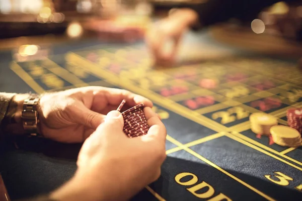 Fichas nas mãos de um jogador em um cassino . — Fotografia de Stock