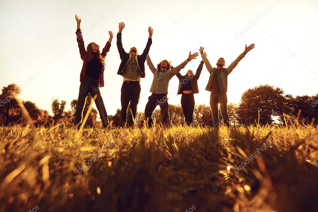 Young people cheerfully raised their hands up.