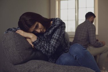 Genç bir çift bir odada kanepede otururken tartışıyor..