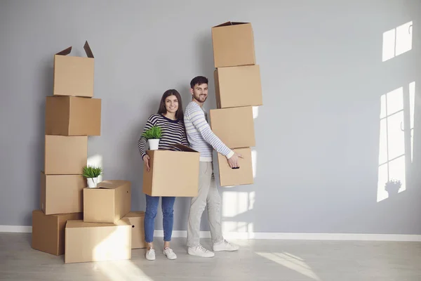 Famille de jeunes couples avec des boîtes pour déménager dans une nouvelle pièce de la maison. — Photo