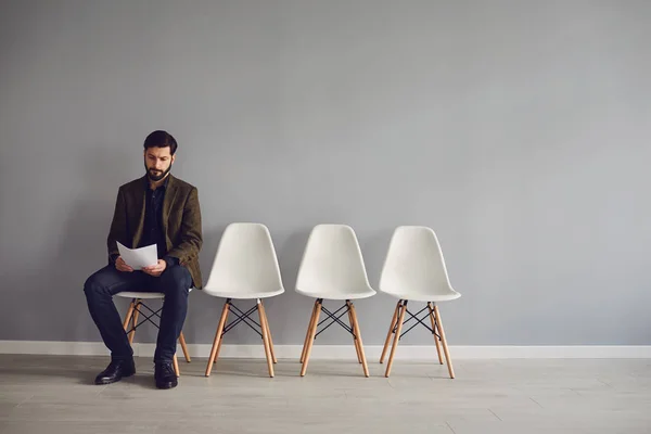 Worker awaits interview sitting on a chair in the room. — Stock Photo, Image