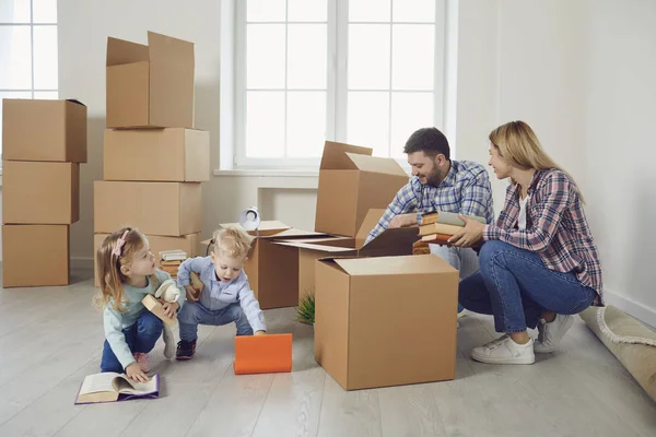 Szczęśliwa rodzina z dziećmi przeprowadzka z pudełkami w nowym domu apartamentowym. — Zdjęcie stockowe