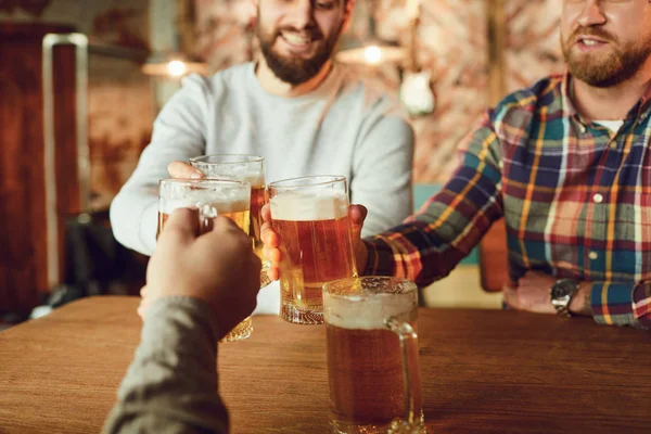 Friends people drink beer, talk in a pub.