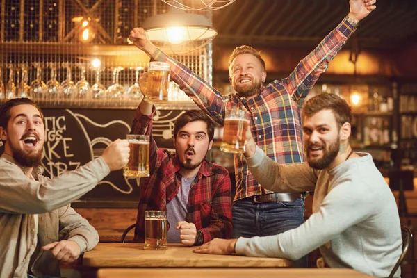 Een groep jongens kijken naar sport op tv in een pub bar. — Stockfoto