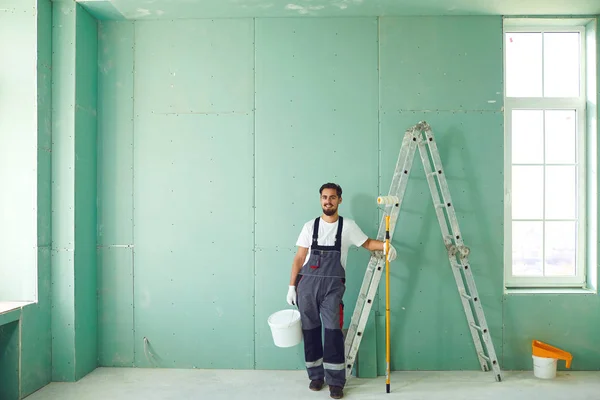 Trabalhador de construção de pintor barbudo em um canteiro de obras . — Fotografia de Stock