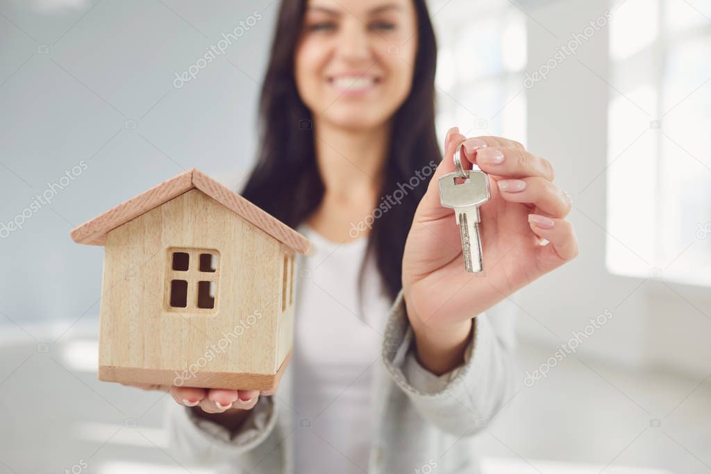 Realtor agent is a realtor with keys in hand against the background of a white real estate room apartment home.