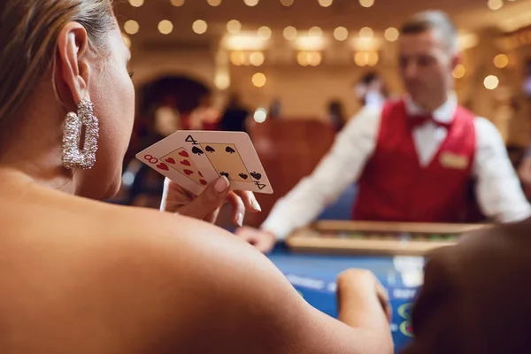 Karte in einer Hand Pokerspielerin Mädchen am Tisch in einem Casino — Stockfoto