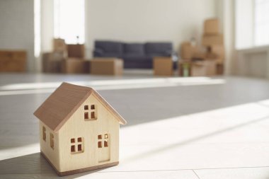 Model of the house on the floor in the new bright sunny house.
