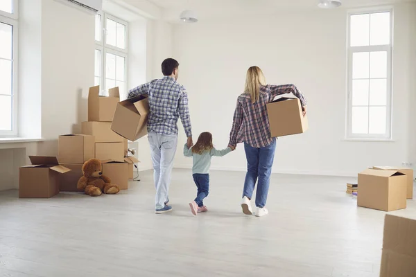 Glad familj med barn flyttar med lådor i ett nytt lägenhetshus. — Stockfoto