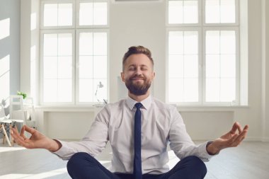 İş adamı ofisteki işyerinde meditasyon yapar..