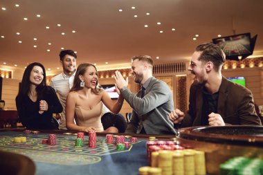 Neşeli bir grup arkadaş kumarhanede poker ruleti kazanmayı sever..