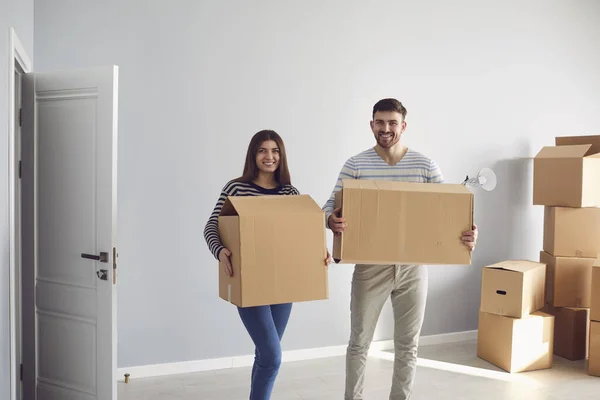 Молода пара сім'ї з коробками для переїзду в новій кімнаті будинку . — стокове фото