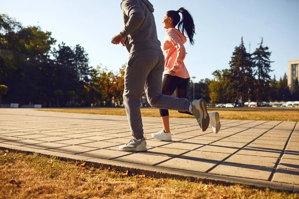 Back view sporty couple are running along the city street in the morning. — Stock Photo, Image