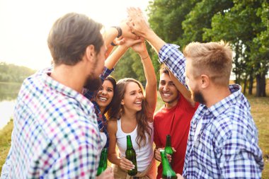 A group of people raised their hands up on a picnic