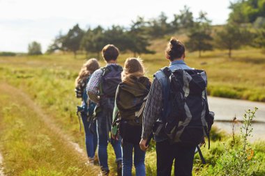 Sırt çantaları ile turist bir grup doğada yürüyor