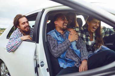Bir grup mutlu arkadaş arabada araba kullanıyor..