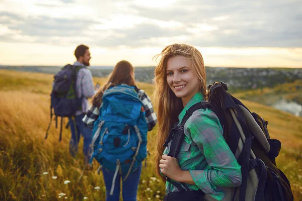 Groupe d'amis trekking avec sacs à dos marchant dans la forêt  . — Photo