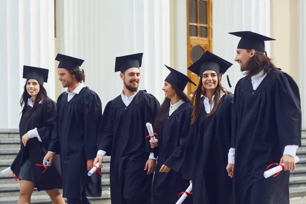 Skupiny absolventů studentů jdou na univerzitu. — Stock fotografie