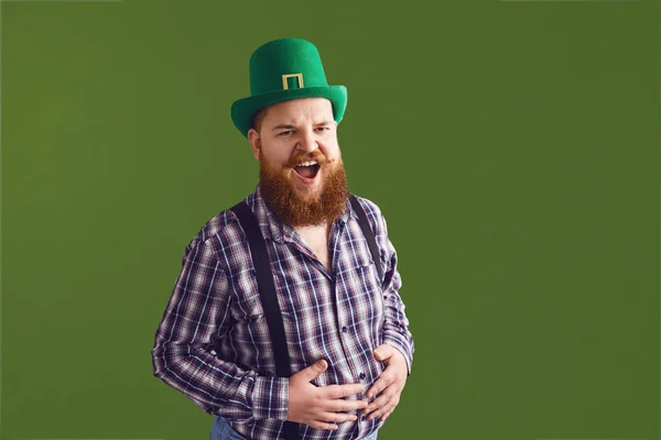 Szczęśliwego Dnia Patricka. Zabawny gruby brodaty mężczyzna w zielonym kapeluszu śmieje się na zielonym tle. — Zdjęcie stockowe