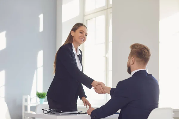 Successful office interview. The conclusion of the contract. Businessman and businesswoman handshake at the table after meeting. — Stock Photo, Image
