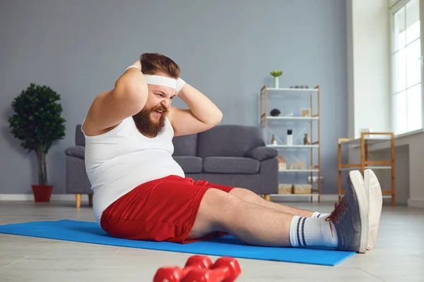 Hombre gordo divertido haciendo ejercicios en la habitación . — Foto de Stock