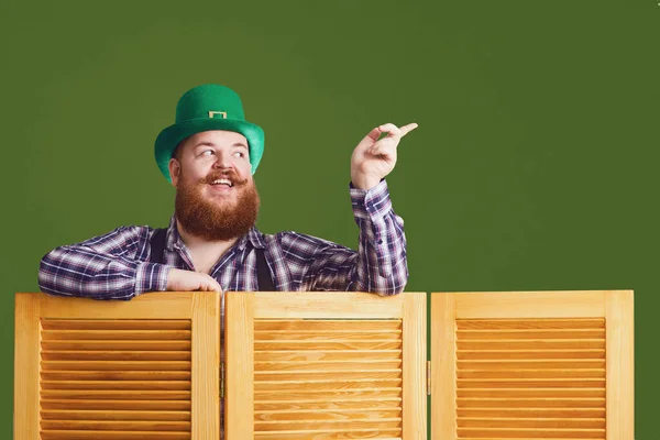 Happy St Patricks Day. Fat funny bearded man hat points a finger at green Patricks day background — 스톡 사진