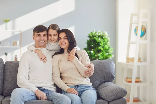 Щаслива родина вдома. Мати батько і дочка сидять на дивані в кімнаті . — стокове фото