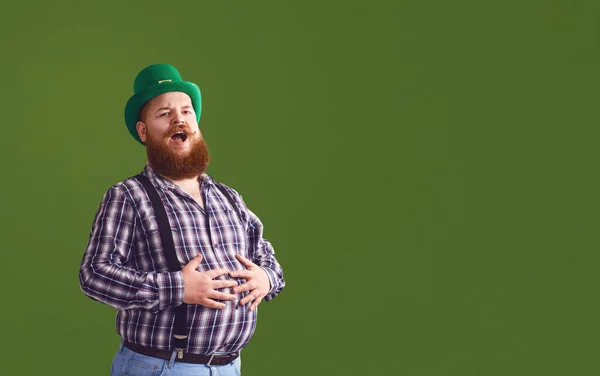 Szczęśliwego Dnia Patricka. Zabawny gruby brodaty mężczyzna w zielonym kapeluszu śmieje się na zielonym tle. — Zdjęcie stockowe