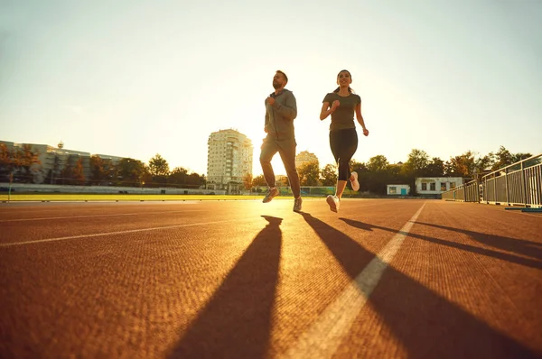 Ung man och kvinna löpare springa på morgonen i gryningen. — Stockfoto