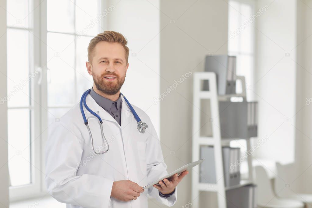 Male doctor pediatrician standing in the white office of the hospital.