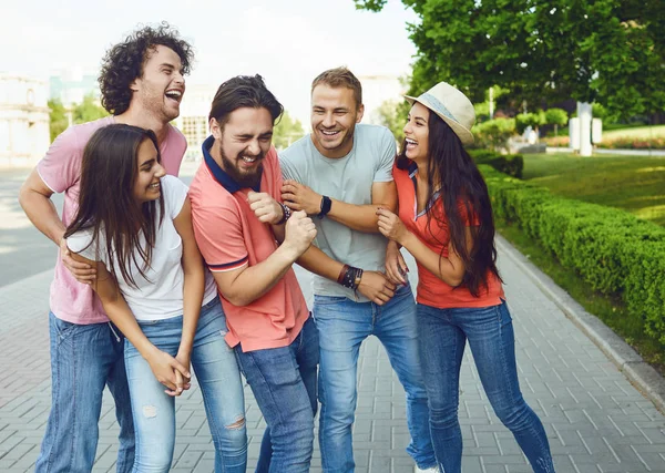 Молоді люди сміються на зустрічі на вулиці міста . — стокове фото