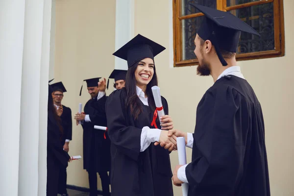 Diplomás diákok kezet ráznak az egyetemen.. — Stock Fotó