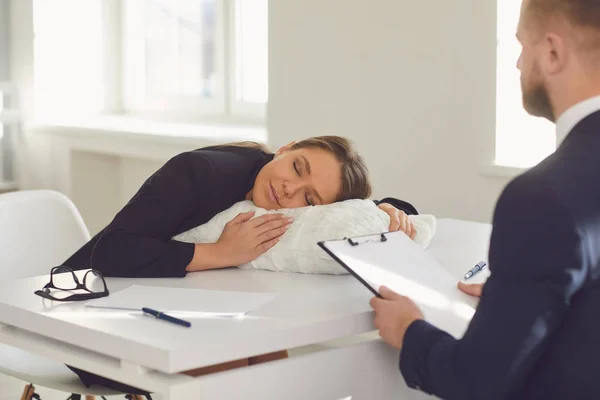 Концепция плохого нотариуса. Женщина-адвокат спит на подушке в офисе за столом — стоковое фото