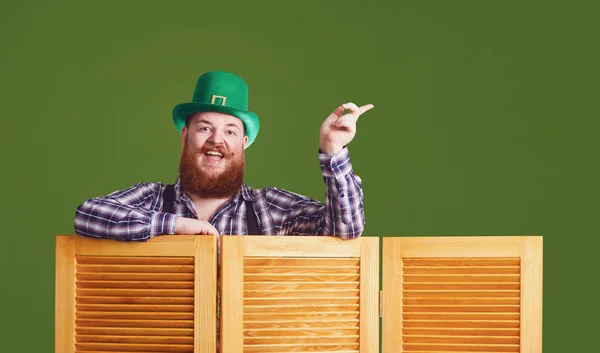 Happy St Patricks Day. Fat funny bearded man hat points a finger at green Patricks day background — 스톡 사진