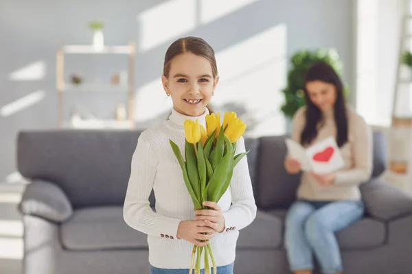 Щасливий день матері. Дочка дитина дарує мамі букет квітів подарунок у кімнаті — стокове фото