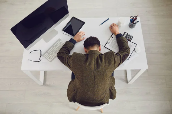 Tired exhausted businessman sleeps with stress problems lying at workplace in office.