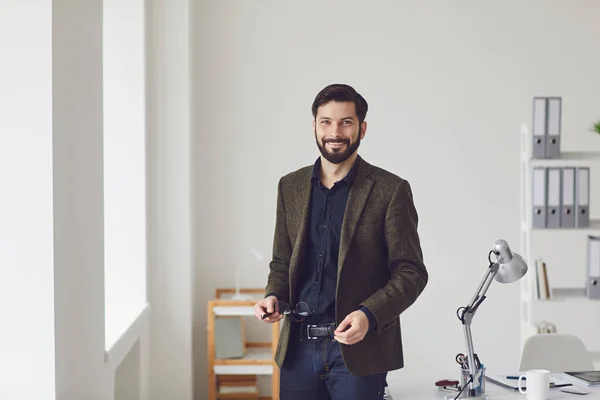 Hombre de negocios sonriente con gafas en la oficina moderna — Foto de Stock