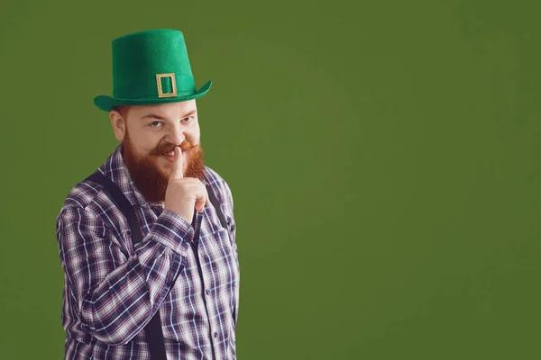Grattis på St. Patricks Day. Fet rolig man i en grön hatt ler på en grön bakgrund Patricks Day. — Stockfoto