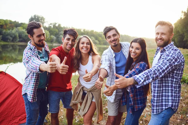Gruppo di persone sorridenti in piedi su un picnic — Foto Stock