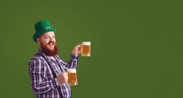 Happy St. Patricks Day. Fat man in a green hat holds his hands up glasses with beer — ストック写真