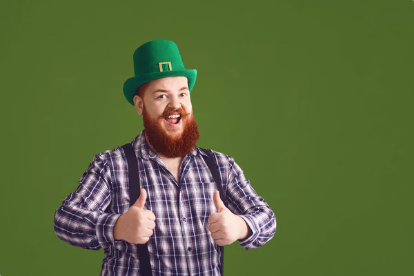 Feliz dia de St. Patricks. Gordo homem engraçado em um chapéu verde sorri em um fundo verde Dia das Patricks . — Fotografia de Stock