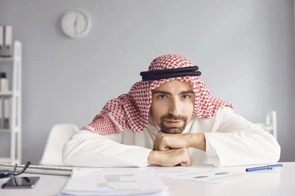 Nyugodt arab férfi ül egy asztalnál egy irodai szobában — Stock Fotó
