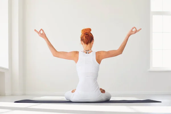 Chica del yoga. Retrospectiva. Chica de fitness está practicando yoga en una posición de loto sentado en un estudio — Foto de Stock