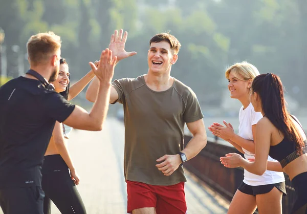 Guy běžec běží zábavu se skupinou přátel v parku — Stock fotografie